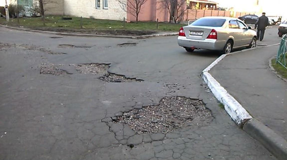 Київські дорожники "працюють": У подвір`ях Троєщини машини провалюються у ями (ФОТОФАКТ) - фото 1