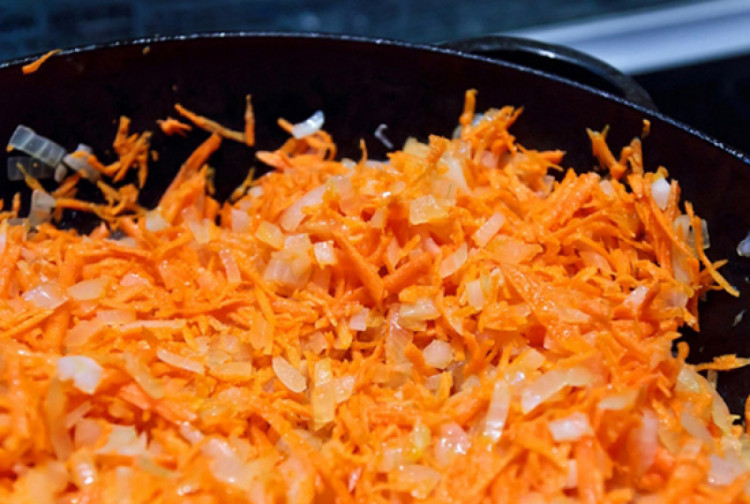 Морква та цибуля обсмажуються на сковороді 