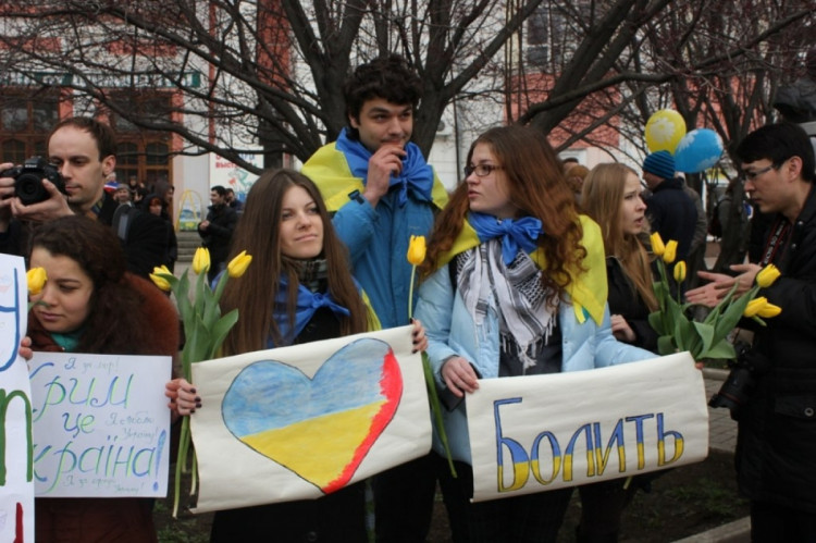 молоді кримчани з плакатами і квітами на мітингу на підтримку України