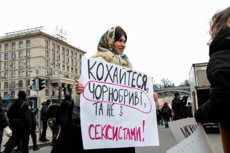 Марш жінок Київ дівчина показує свій плакат