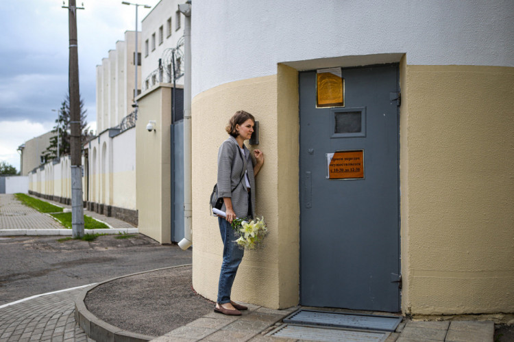 женщина с цветами ждет у дверей СИЗО в Беларуси