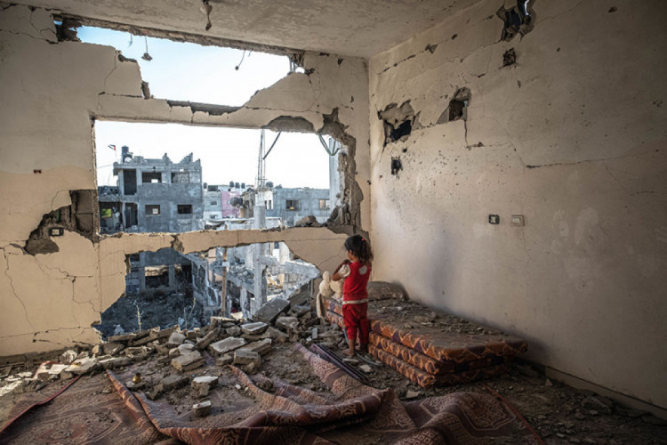 Палестинская девочка стоит в своем разрушенном доме в Бейт-Хануне, сектор Газа