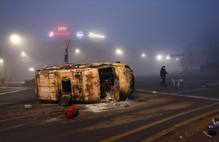 сгоревший автомобиль лежит на дороге в Алматы